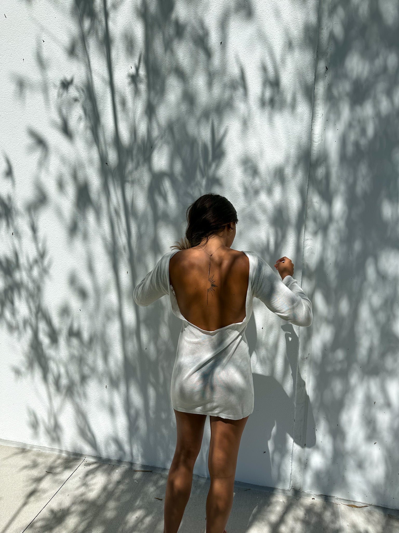 sheer dress sunlight Woman in white sheer dress posing outdoors in sunlight Stock Photo